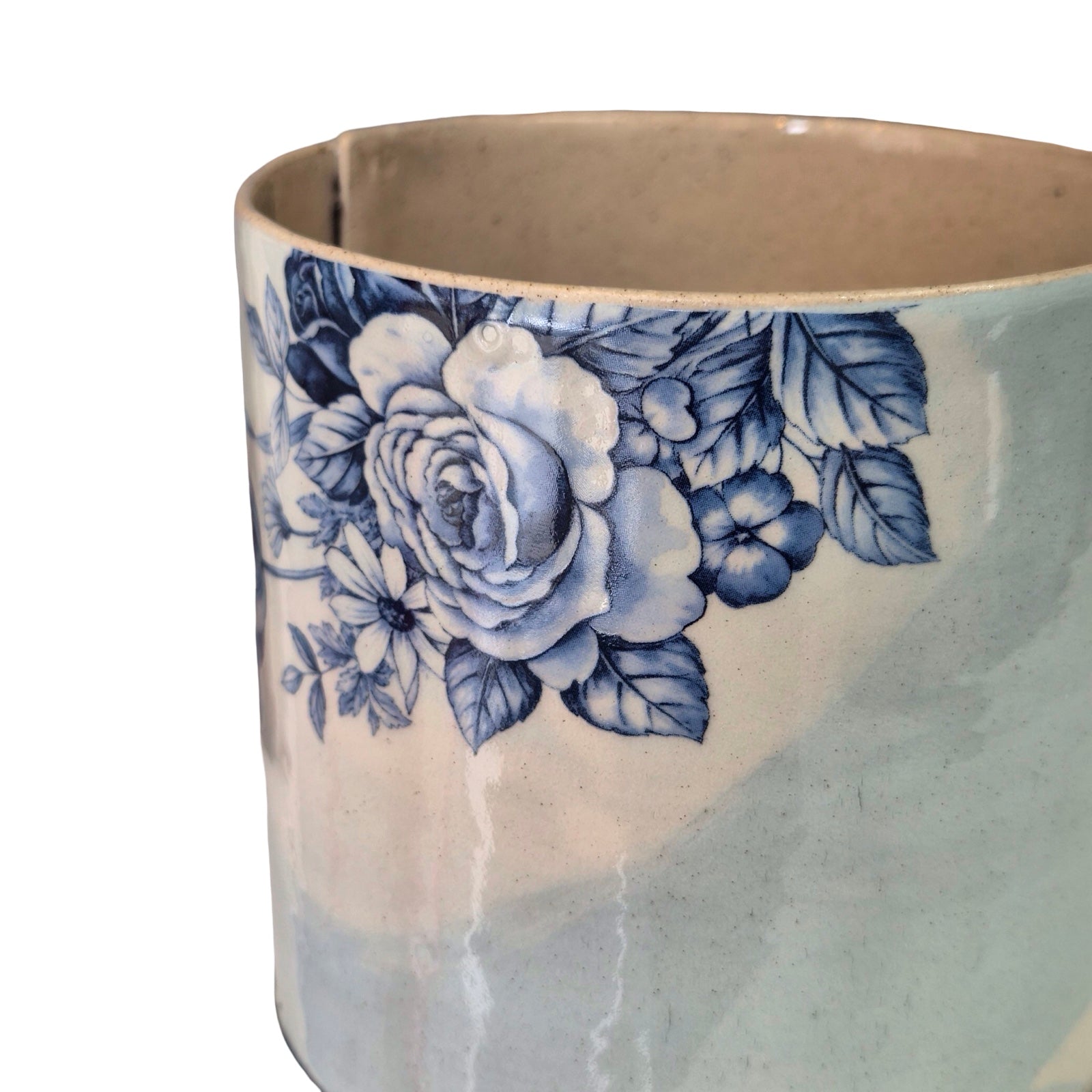 Ceramic planter with blue floral design on a white background.