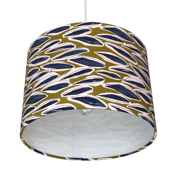 Drum lampshade covered in lime green coloured linen with blue grass dashes