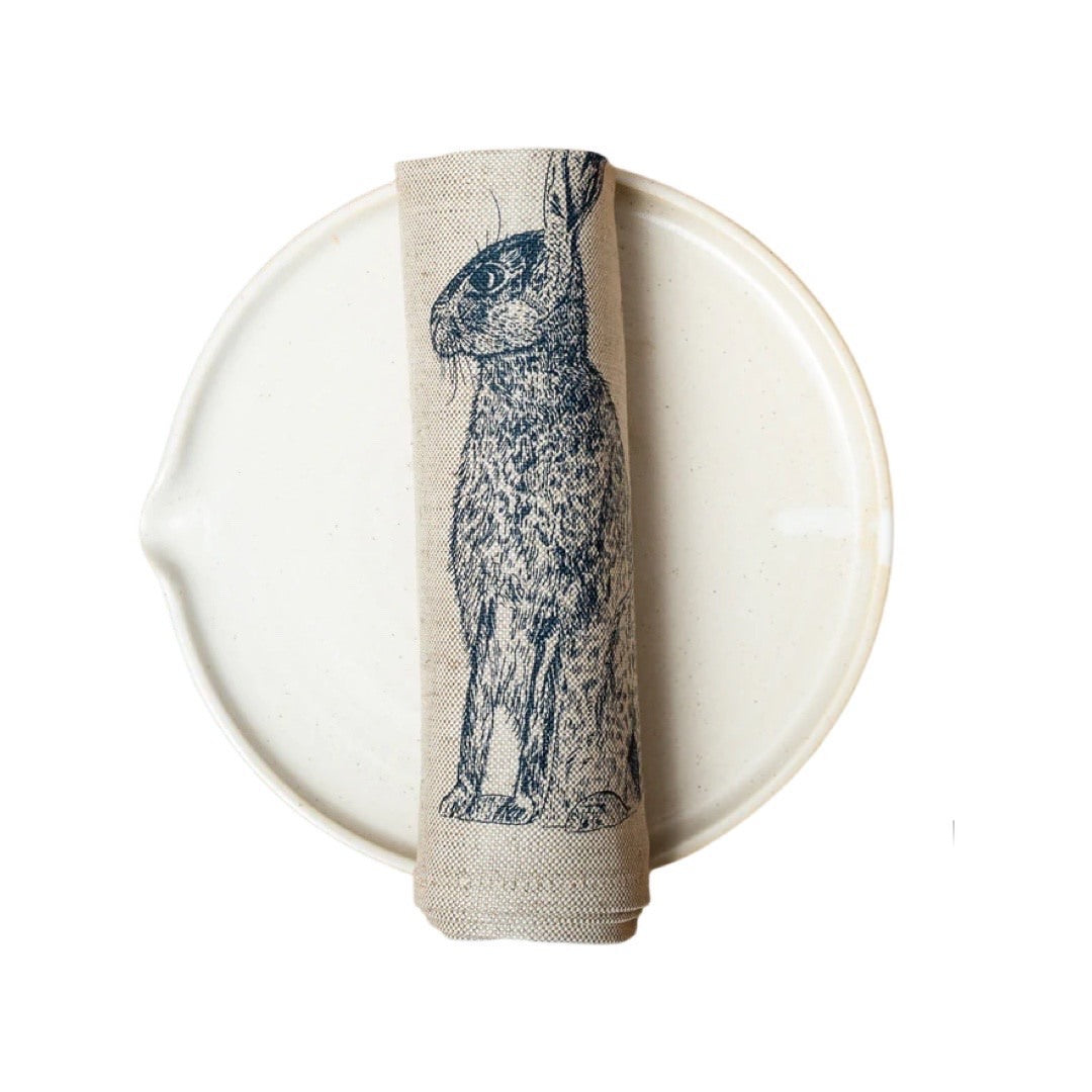 Screen-printed cream serviette featuring an original illustration of a blue hare. 