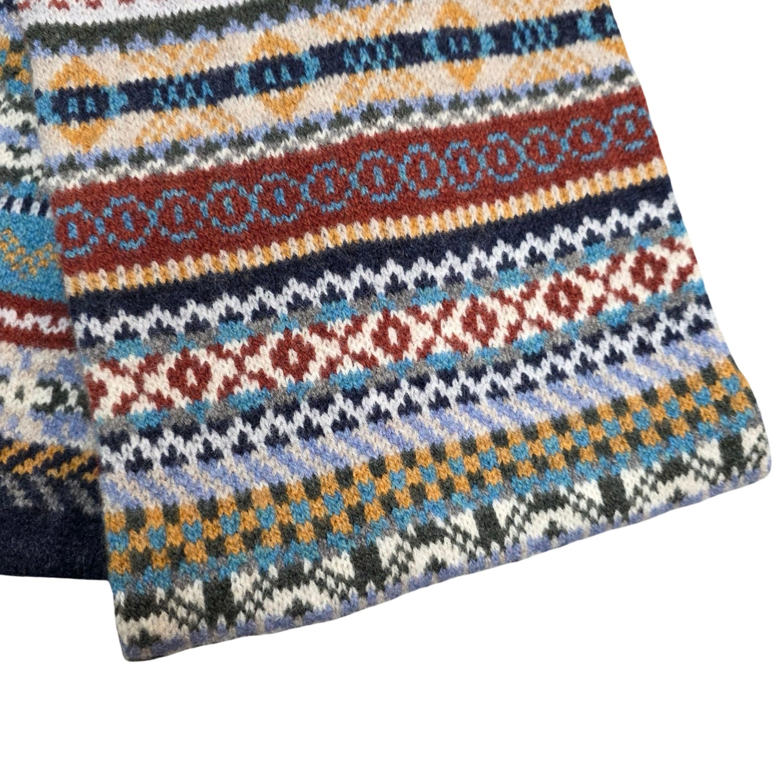 Knitted scarf with a colourful geometric pattern on a white background.