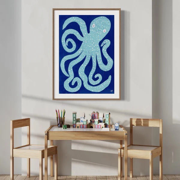 Framed artwork of an octopus on a wall above a wooden children's table and chairs.