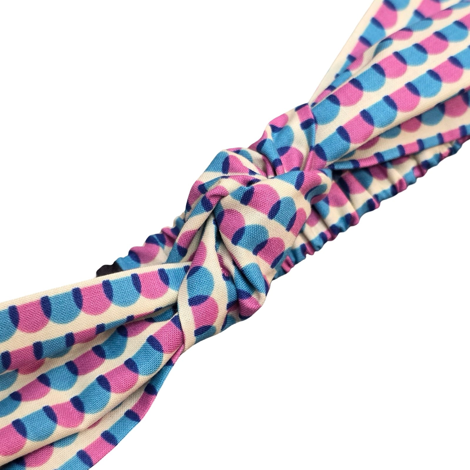 This handmade knotted headband is made from&nbsp;100% cotton fabric with a blue and pink scalloped pattern.
