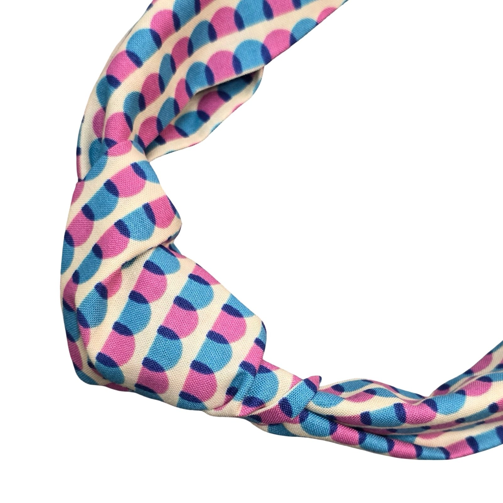 This handmade floral top-knot Alice band is made from 100% cotton fabric with a blue and pink scalloped pattern.