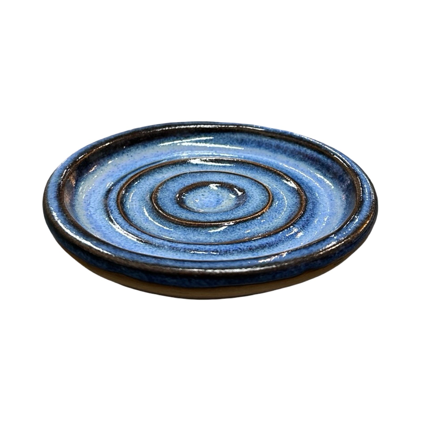Ceramic dish with blue glaze and concentric circle pattern on a white background.