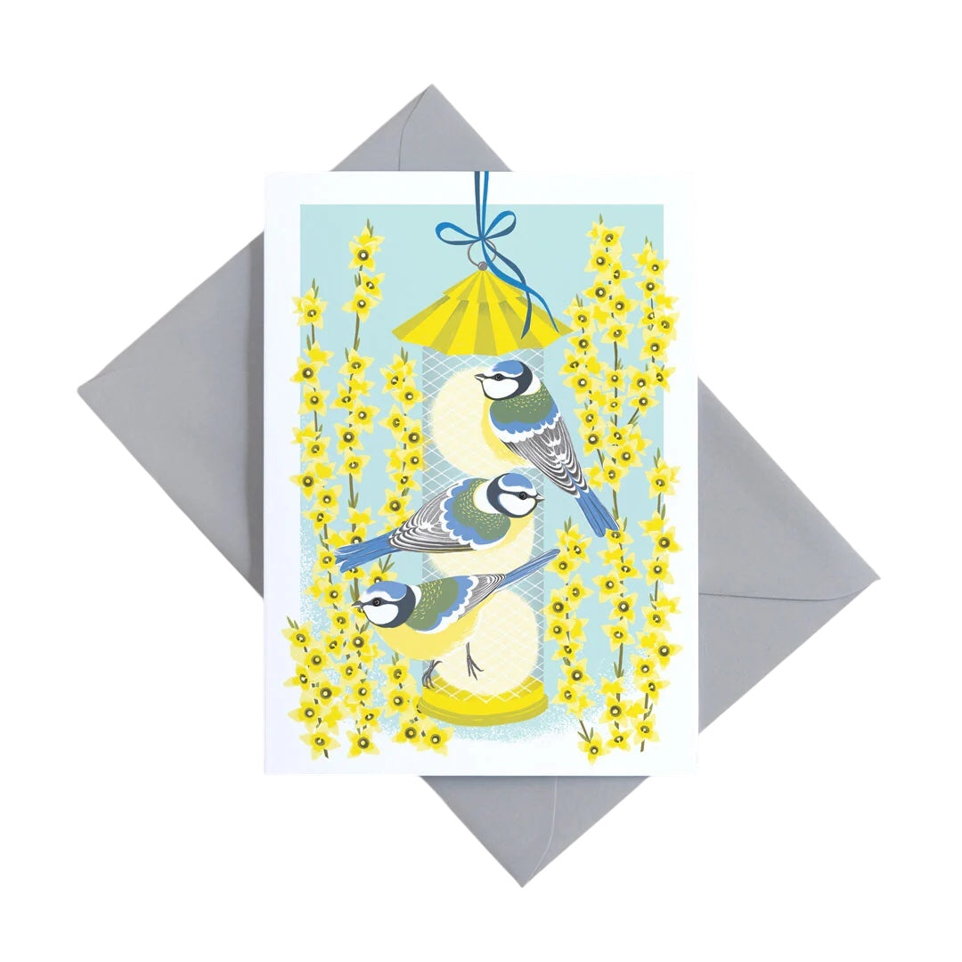 An image of a card with three Blue Tits on a bird feeder. 