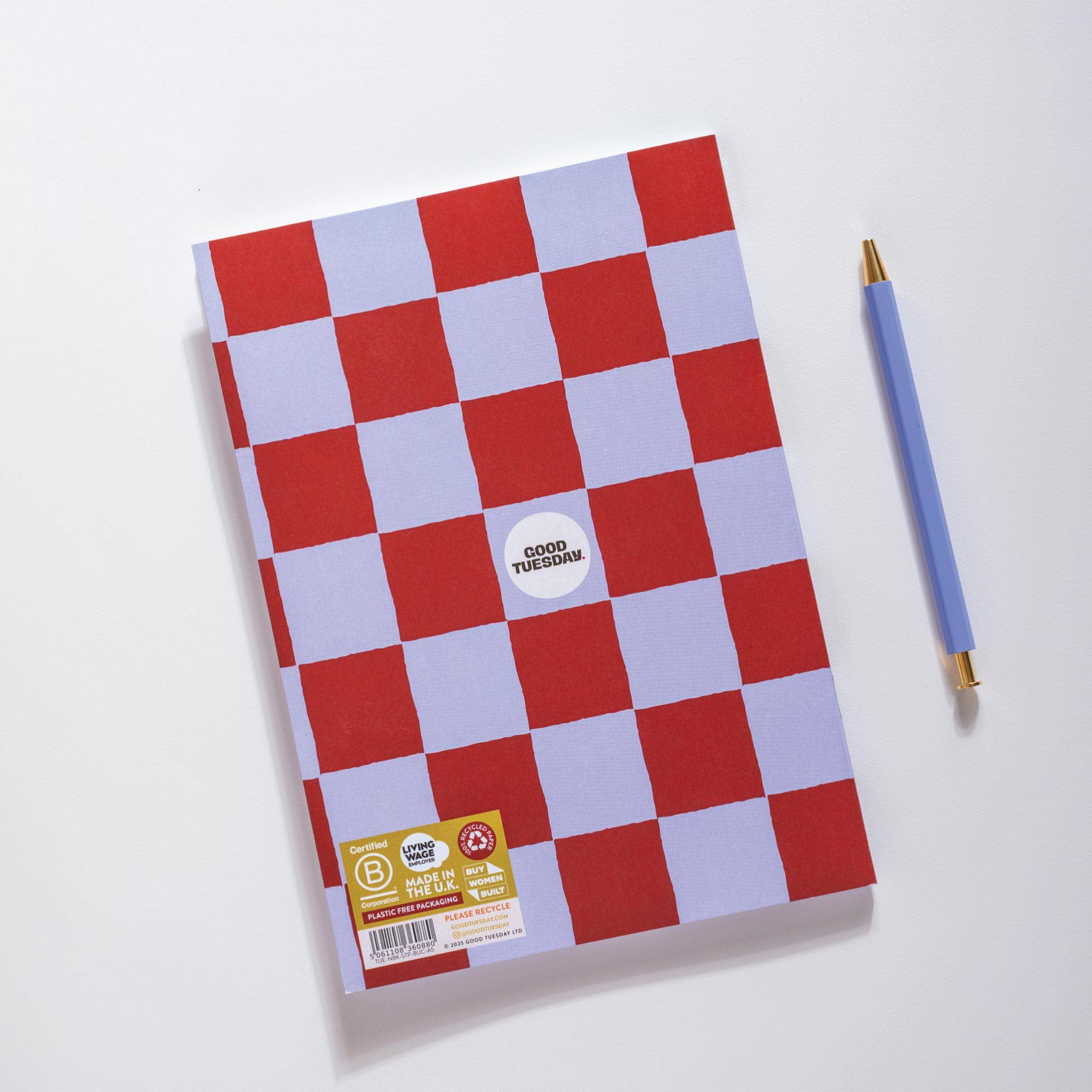 Checkered notebook with a pen on a white background.