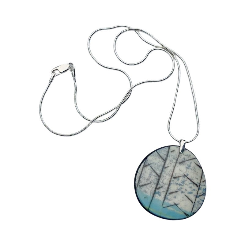 Oval porcelain pendant necklace with a turquoise base and black tree silhouettes on a 18 inch sterling silver chain.