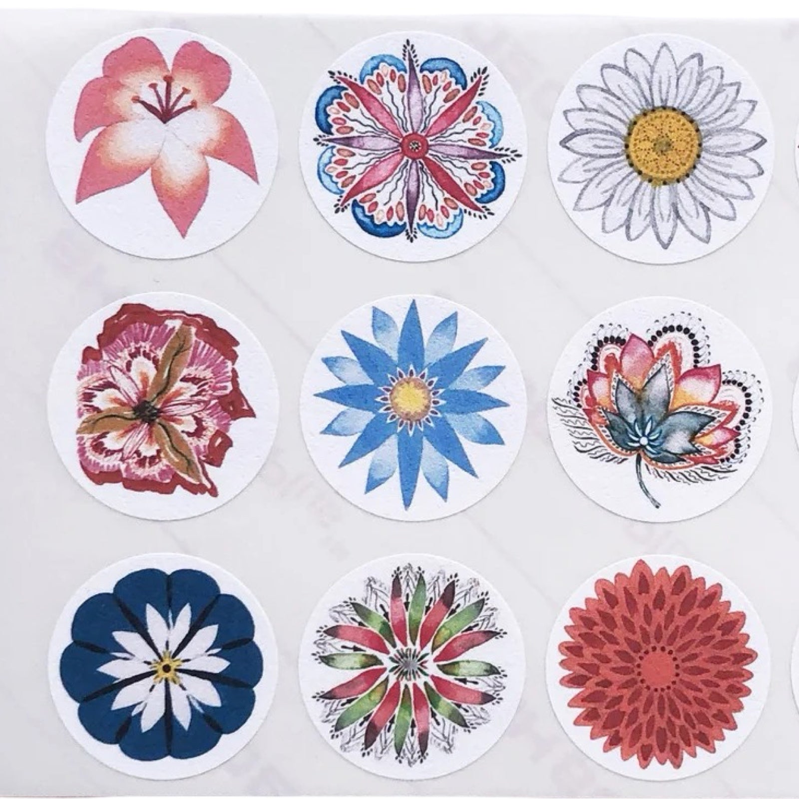Set of circular floral and abstract stickers on a white background.