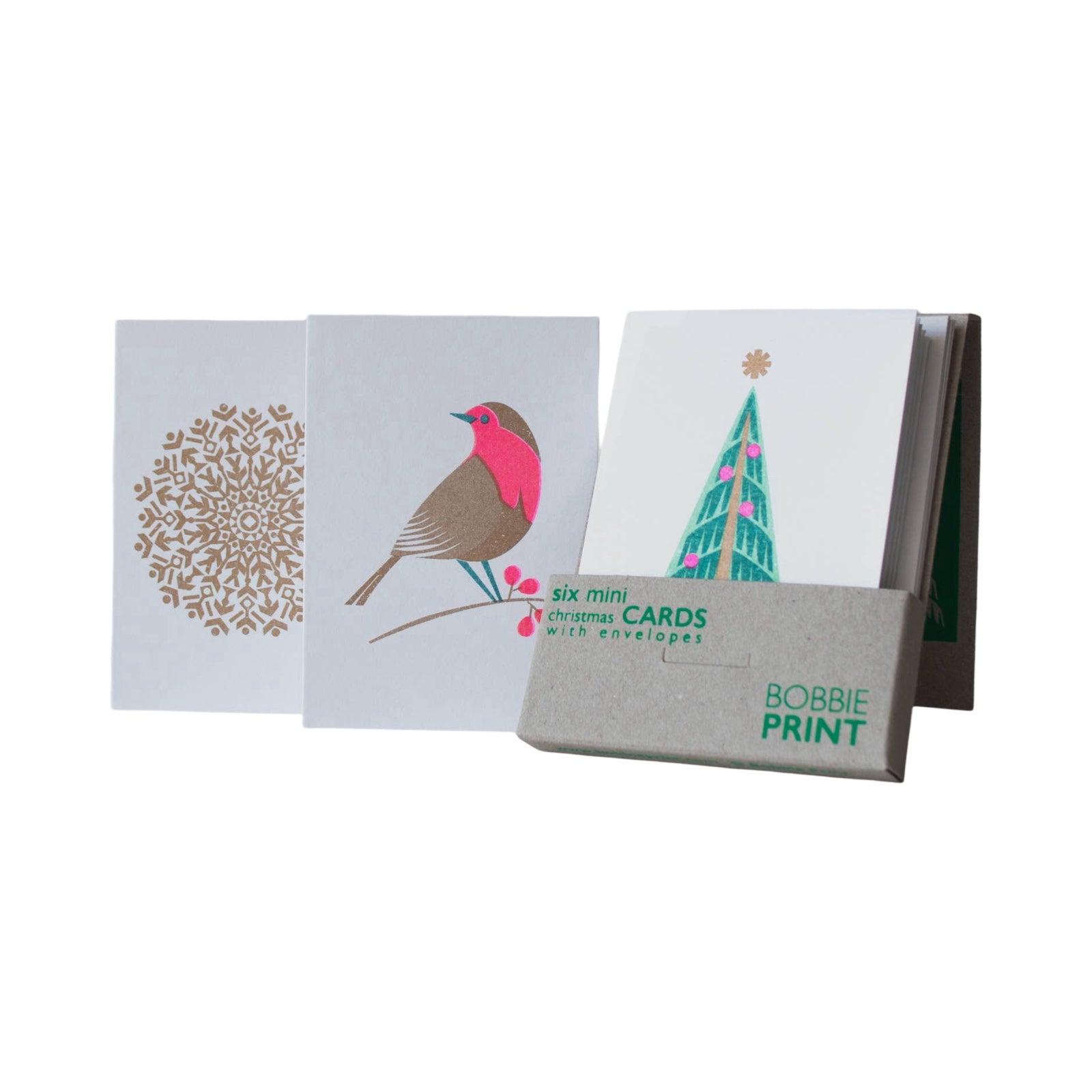 A pack of risograph printed Christmas cards showing 1 card with a large gold snowflake, 1 with a colourful robin and 1 with a green Christmas tree with pink baubles and a gold star