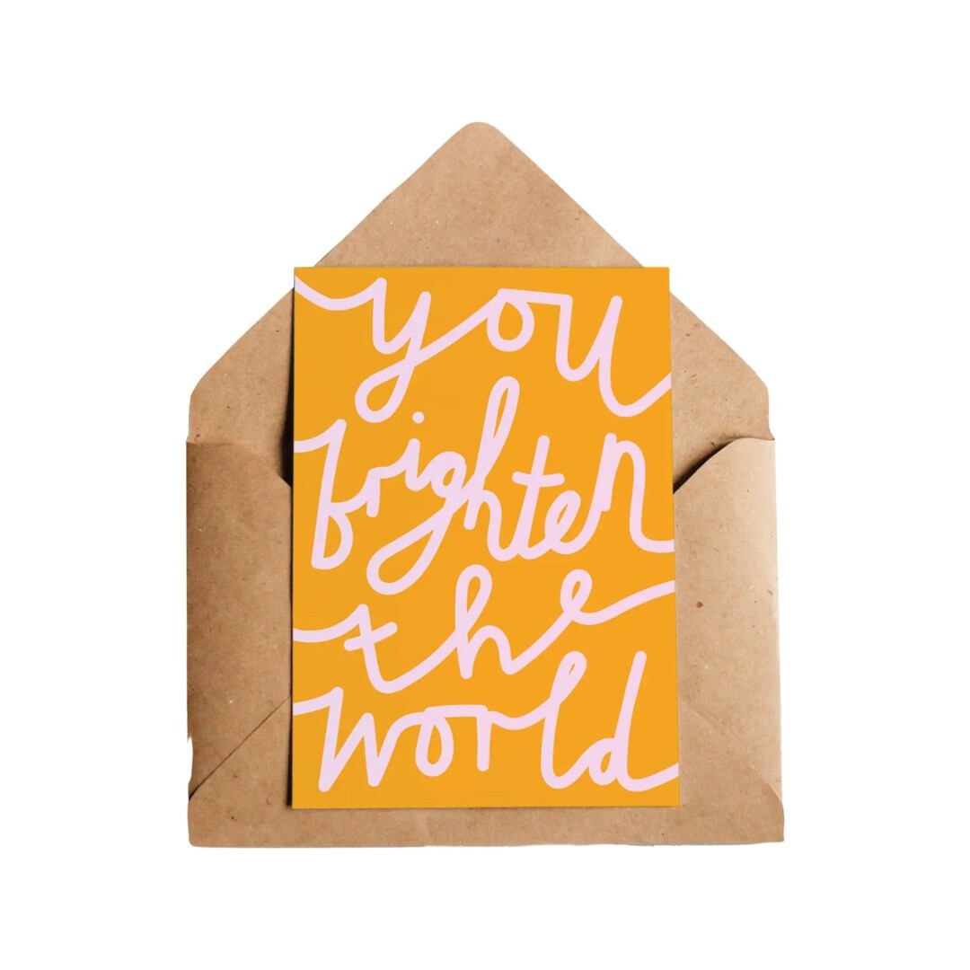 Perfect card for your favourite person, the text 'you brighten the world' in pale pink writing on an orange background.