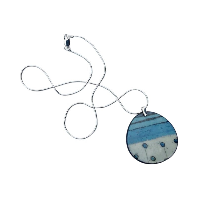 Oval porcelain pendant necklace with an abstract design inspired by nature, in turquoise, cream and black on an 18-inch sterling silver chain.