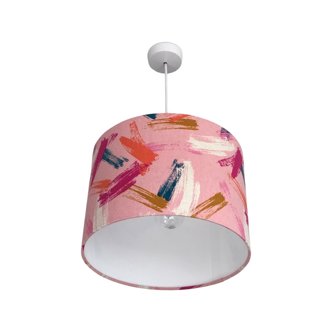 Drum lampshade covered in pink canvas fabric with brush strokes in navy, pink, white, red and brown