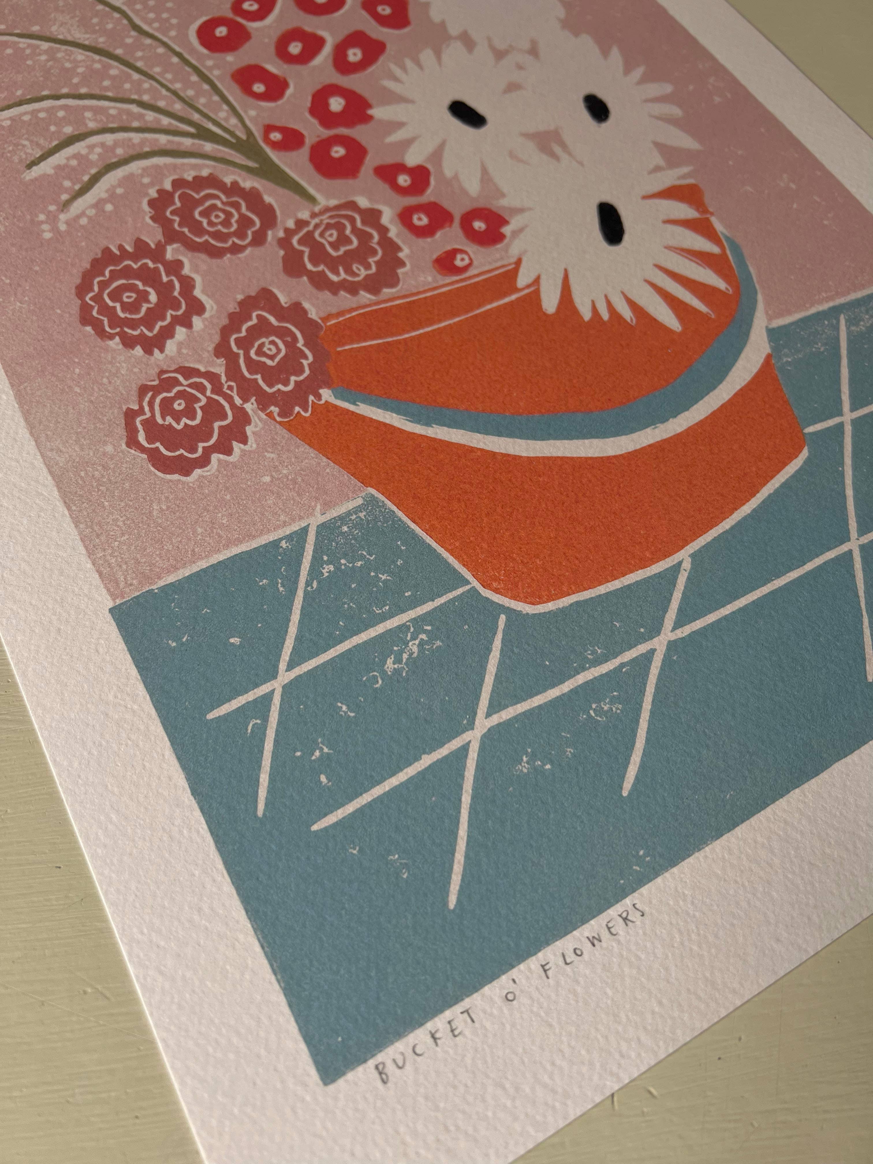This print features an orange bucket full of colourful flowers. 