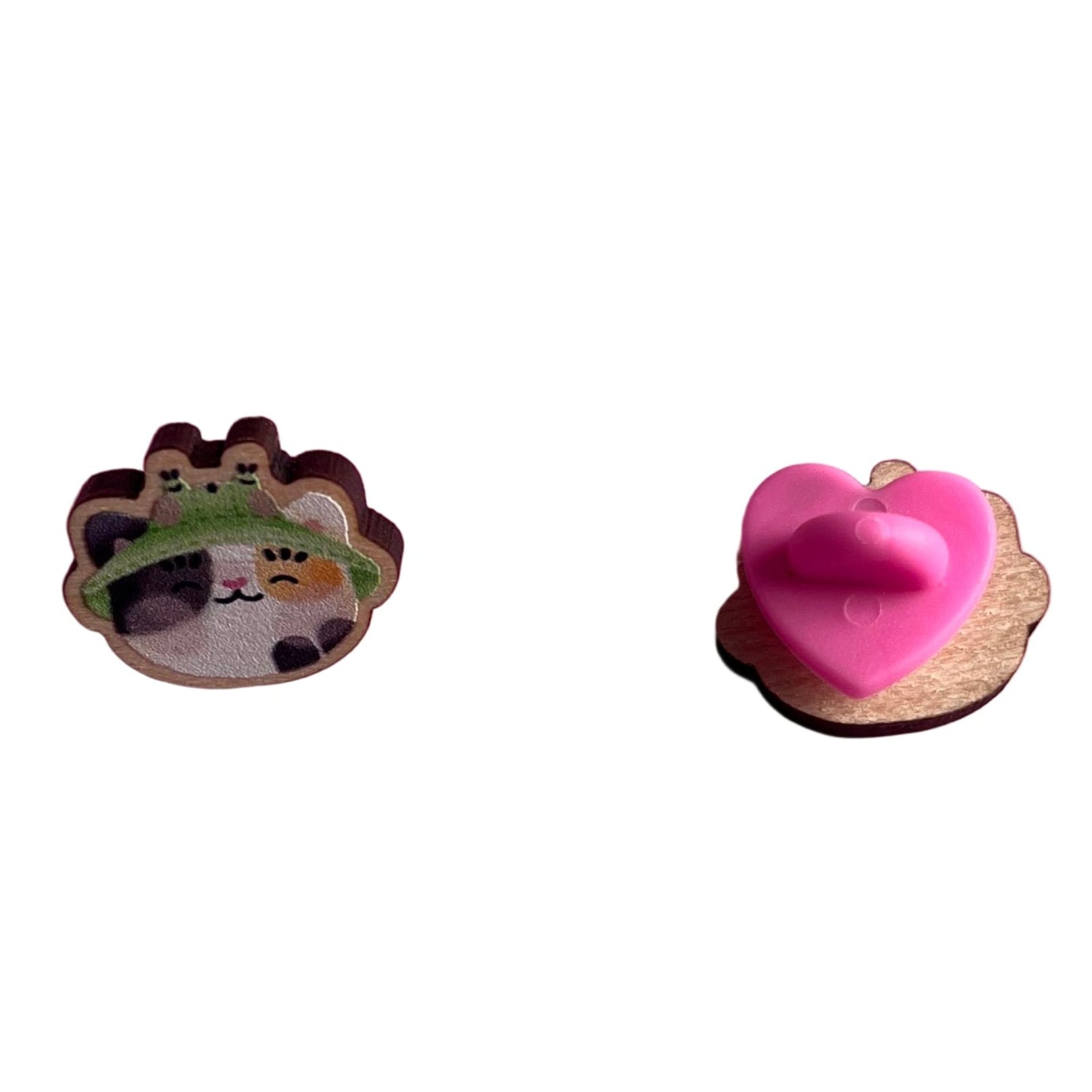 Mini wooden pin badge of a calico cat wearing a frog bucket hat - front (left), back (right)