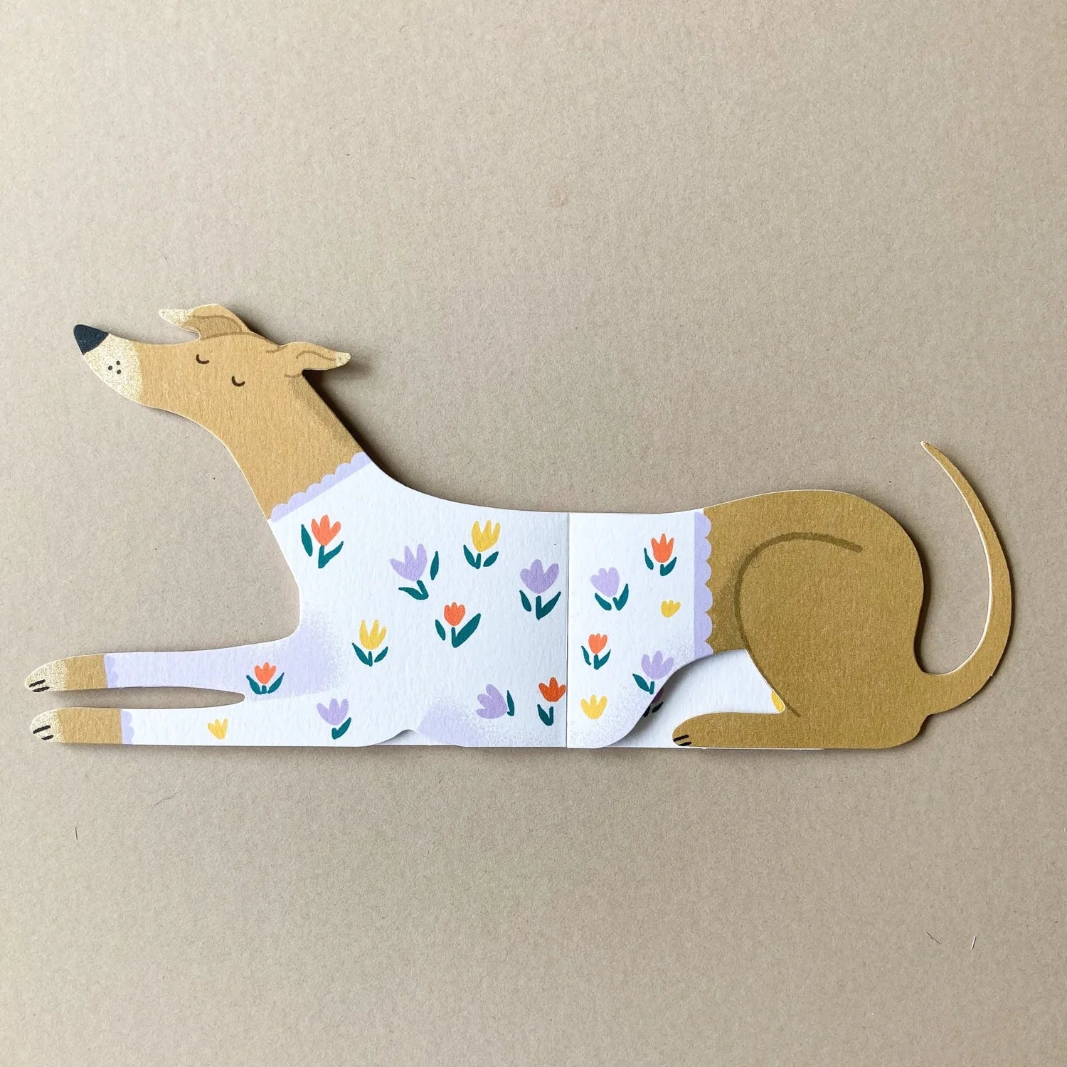 Dog-shaped card with floral pattern on a beige background.