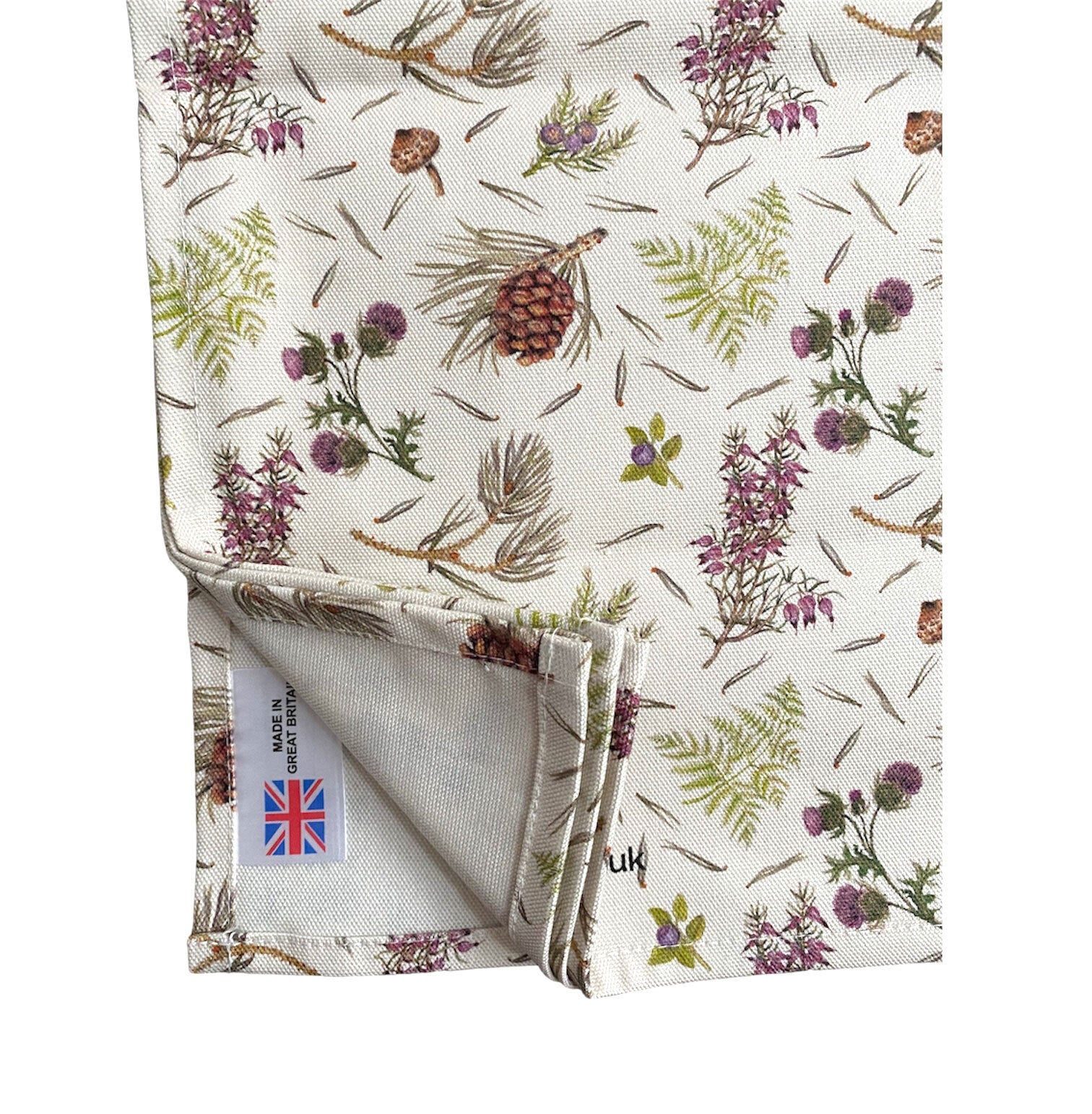 A tea towel featuring illustrations of thistles and acorns against an off-white background.