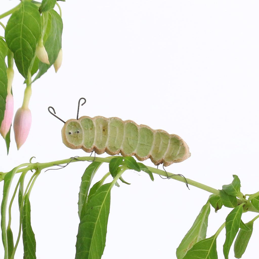 A ceramic caterpillar shaped plate hugger finished with green recycled glass