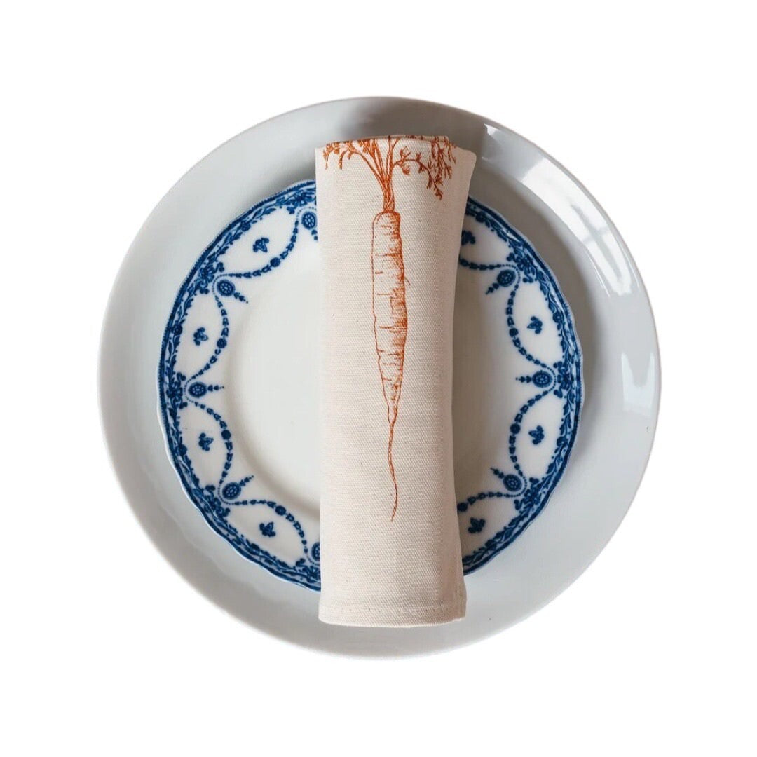 Cream cotton napkin with an orange carrot.