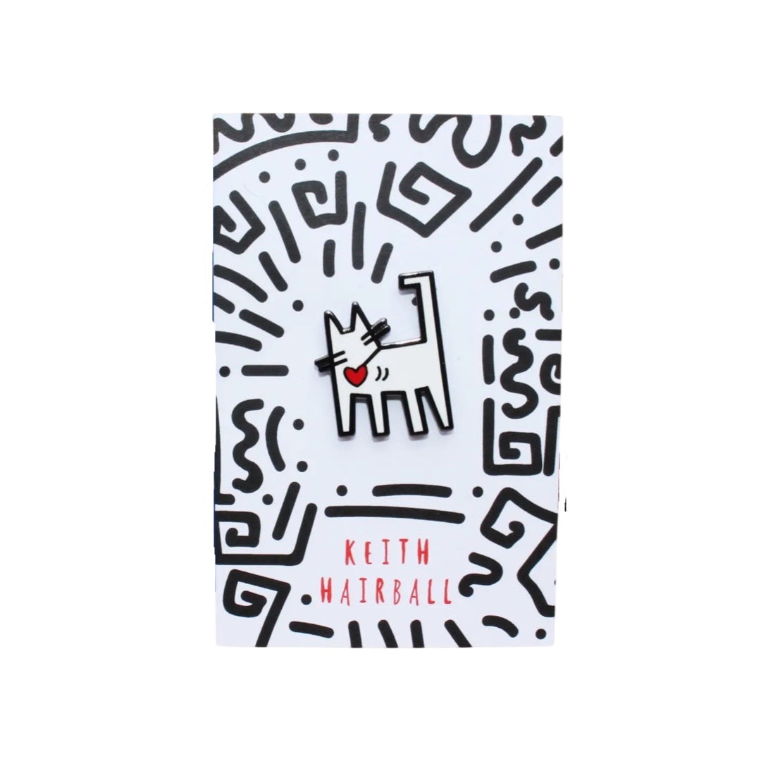 White cat enamel pin badge with a red love heart hanging from its collar, inspired by the work of the pop art master Keith Haring.