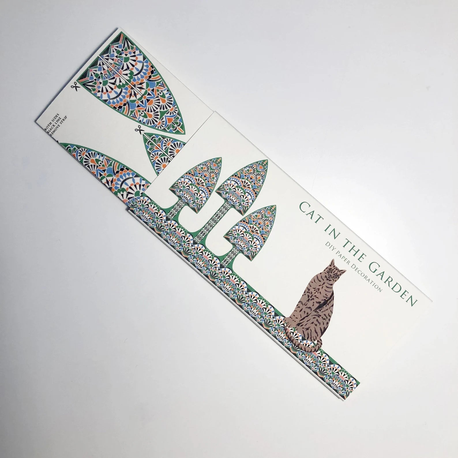 Decorative paper with 'Cat in the Garden' design on a white background.