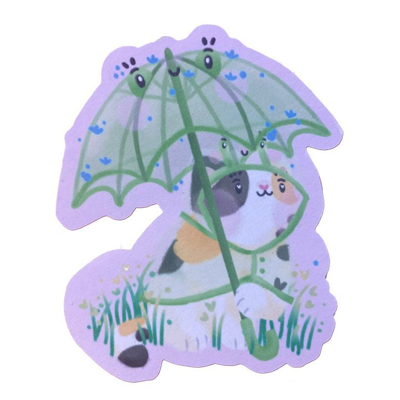 Handmade sticker of a calico cat, wearing a frog raincoat, and holding a matching frog umbrella. 