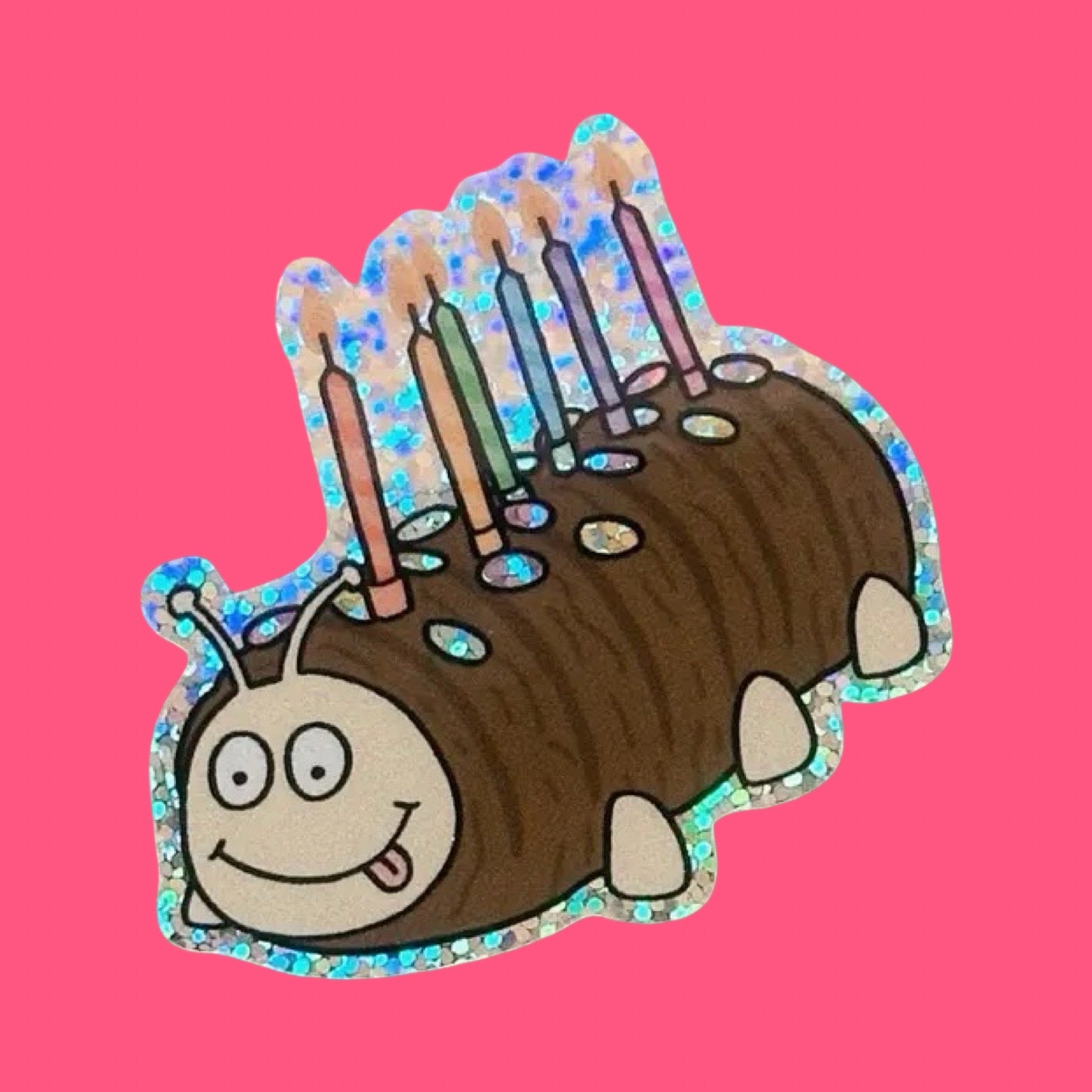 Cartoon caterpillar cake with birthday candles on a pink background.