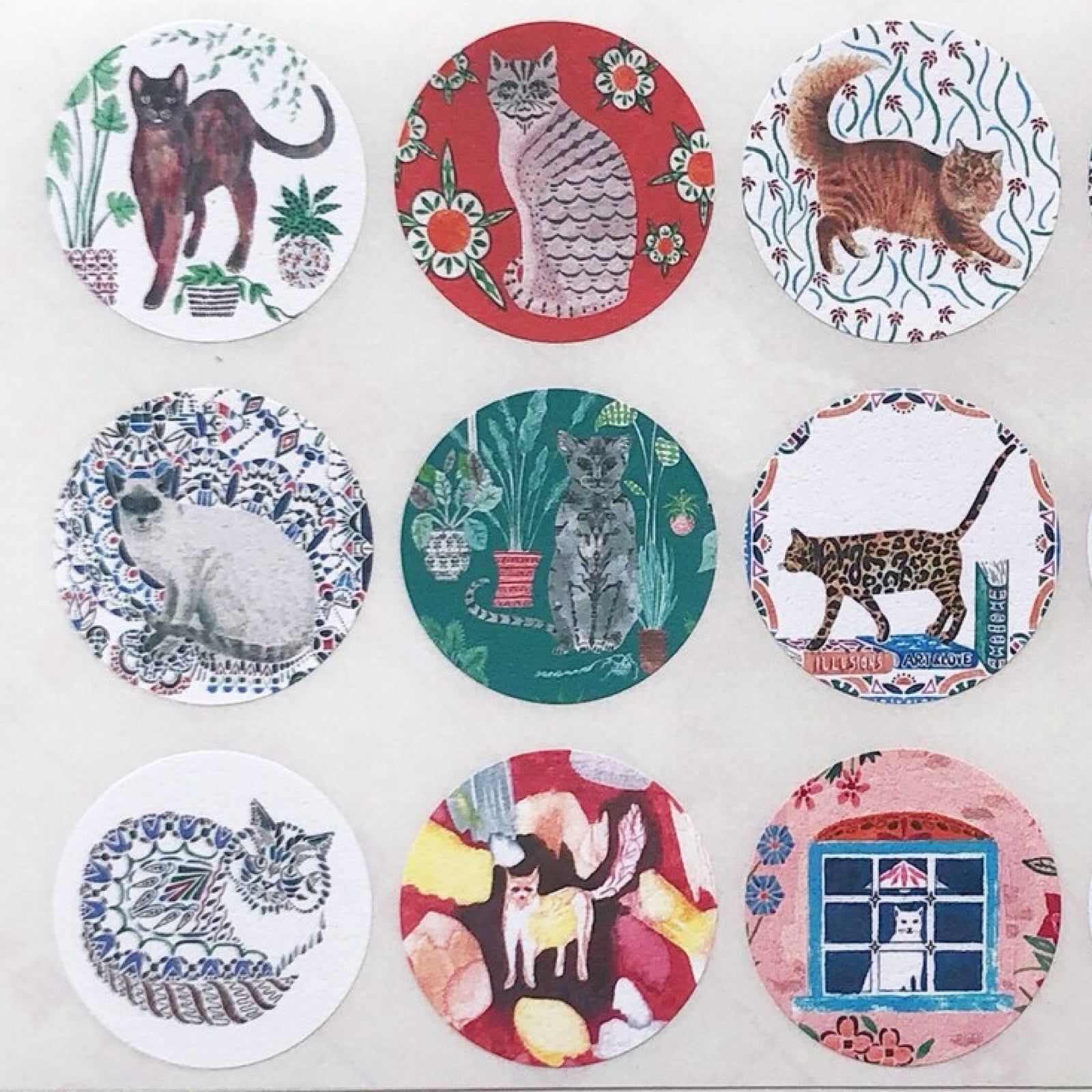 Set of circular stickers with cat illustrations on a white background.