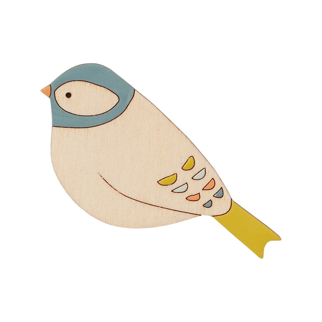 A chaffinch-shaped wooden brooch hand painted with a blue head, orange beak and yellow tail.