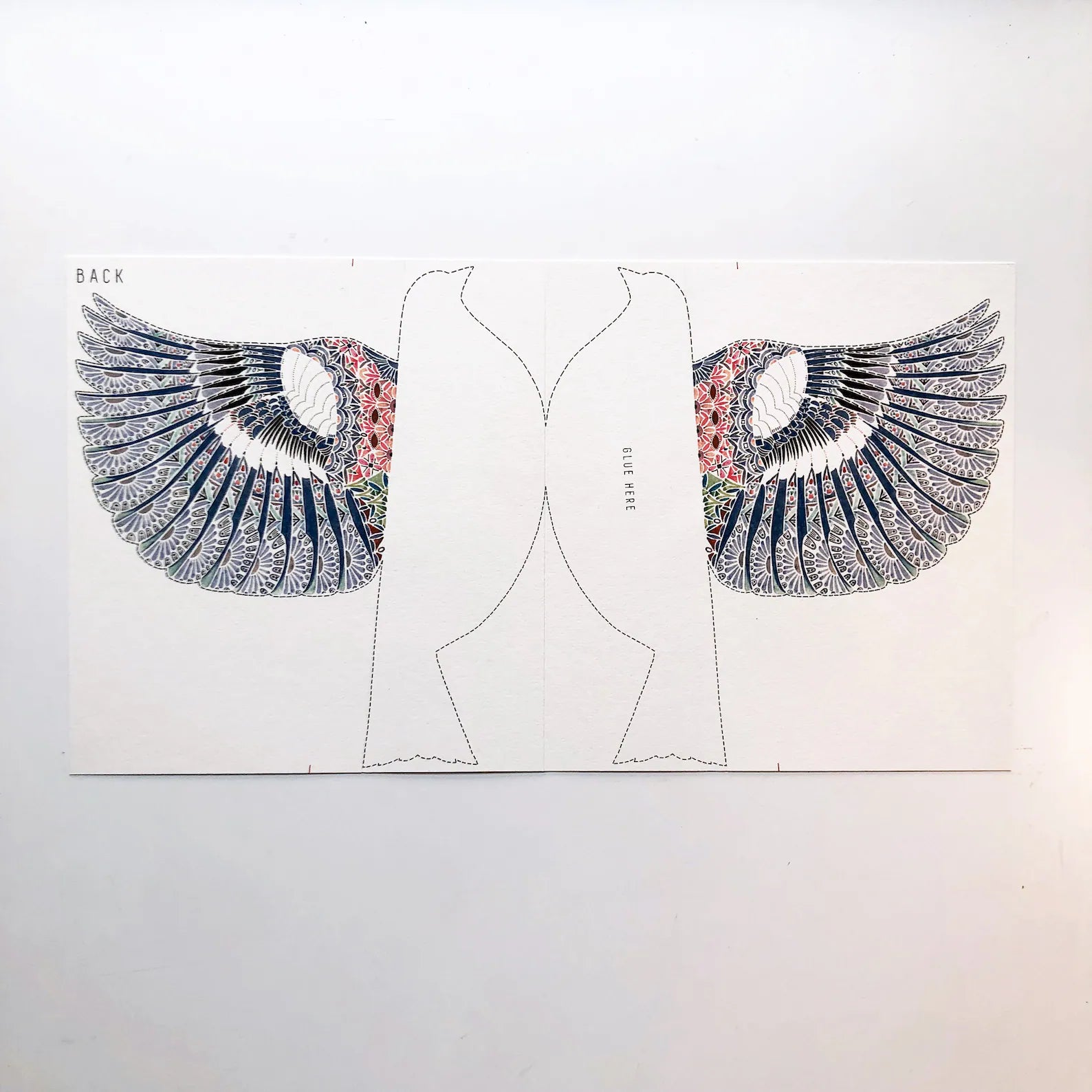 Design of a garment with decorative wings on a plain background.