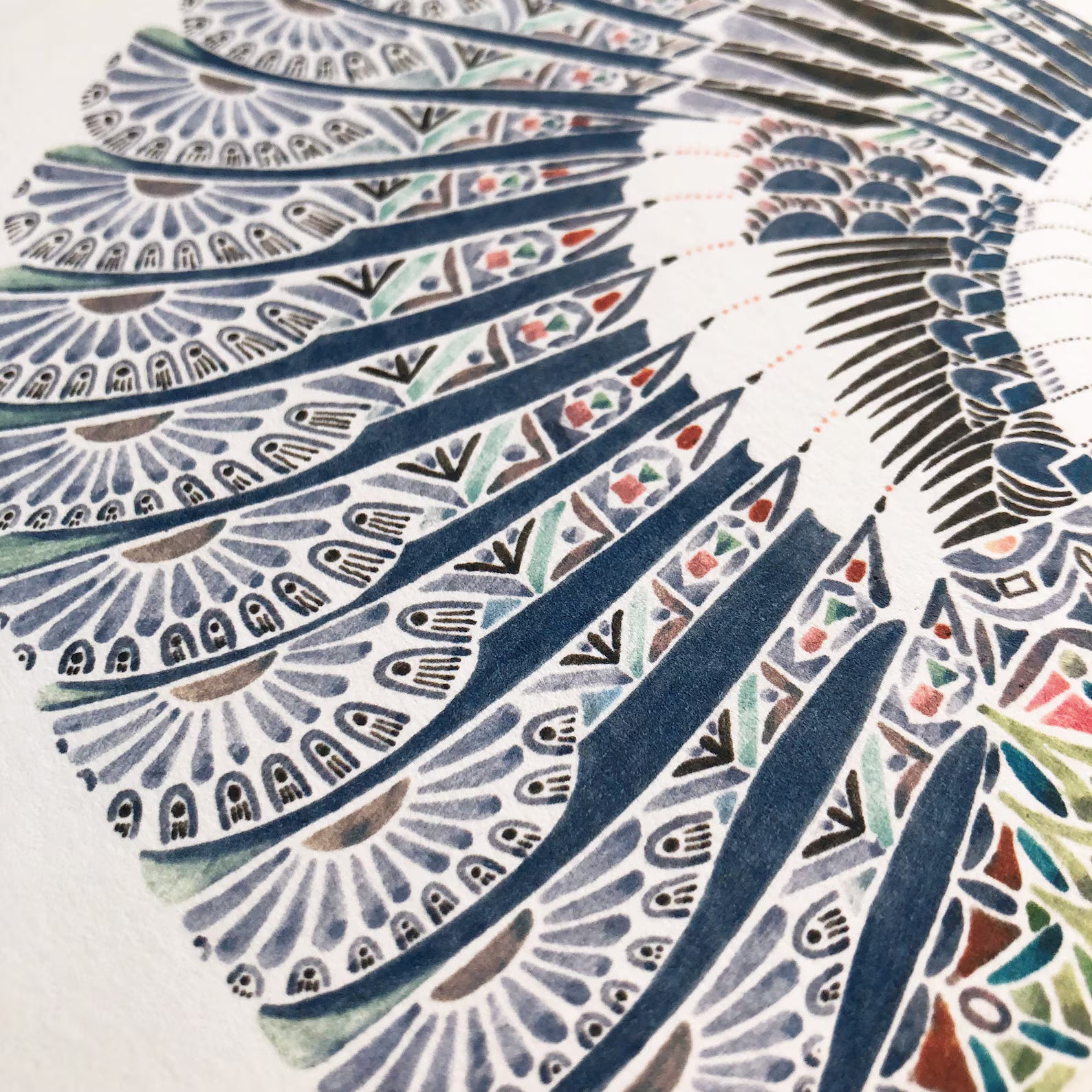 Close-up of a patterned fabric with geometric designs in blue, green, and brown.