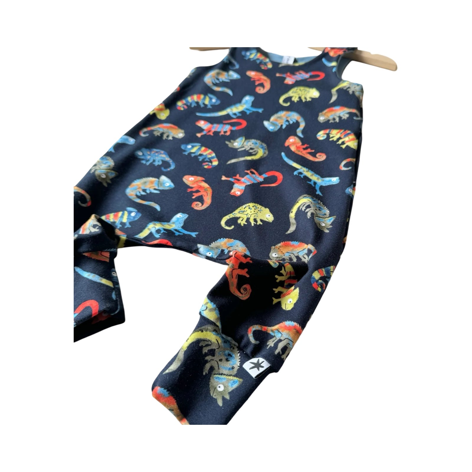 An oversized baby romper with colorful chameleon patterns.