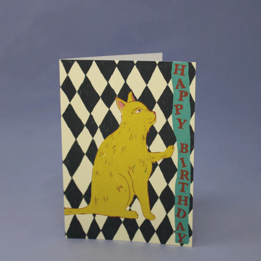 Birthday card with a yellow cat illustration on a black and white checkered background.