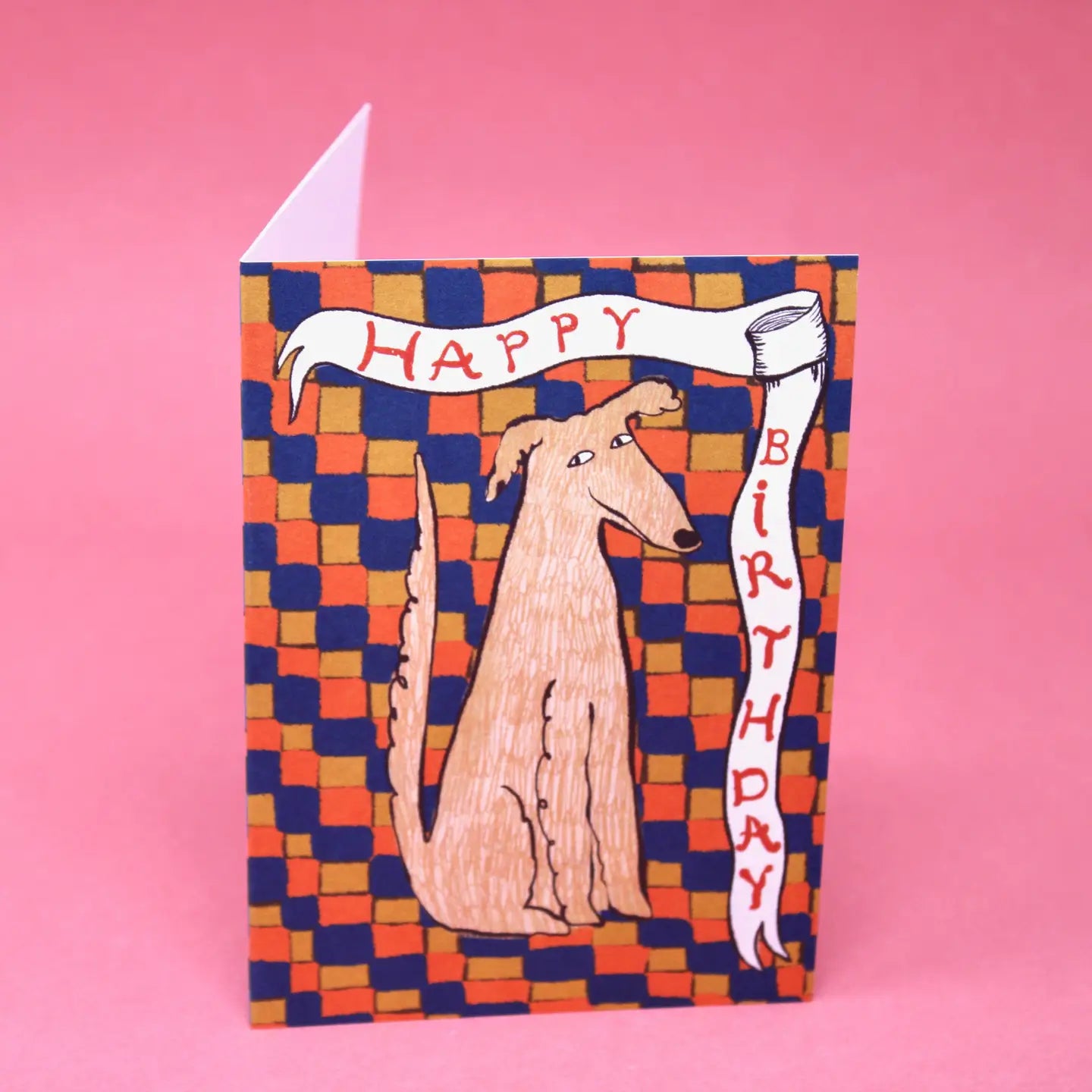 Birthday card with a dog illustration on a checkered background, on a pink background.