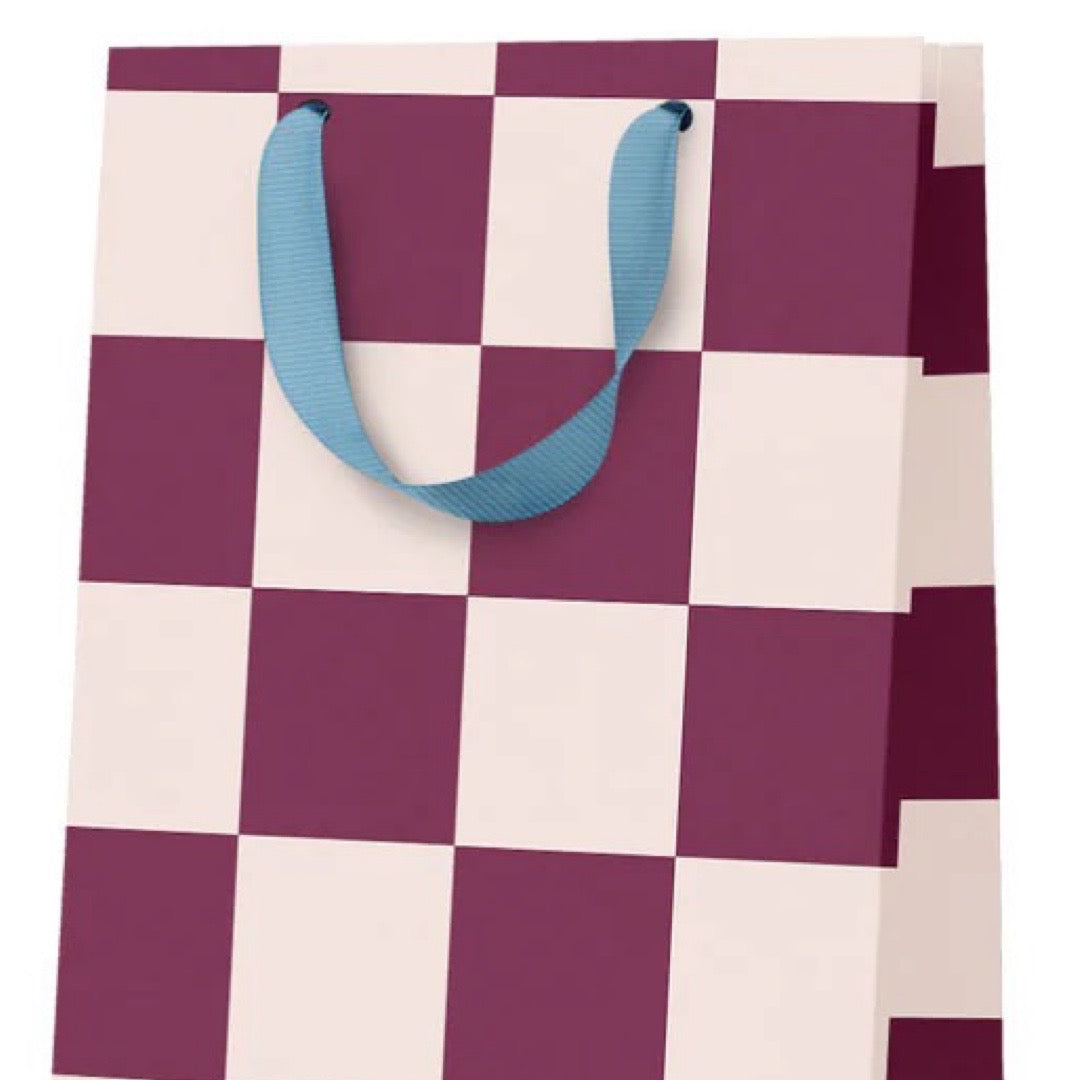 Checkered bag with purple and white squares and blue handles on a white background.