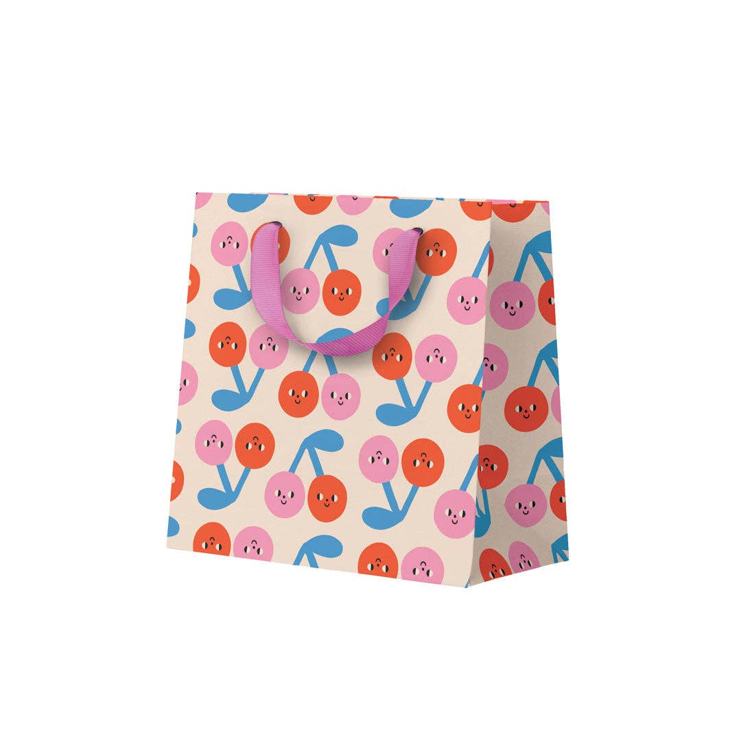 Colourful gift bag with cartoonish cherries on a white background.