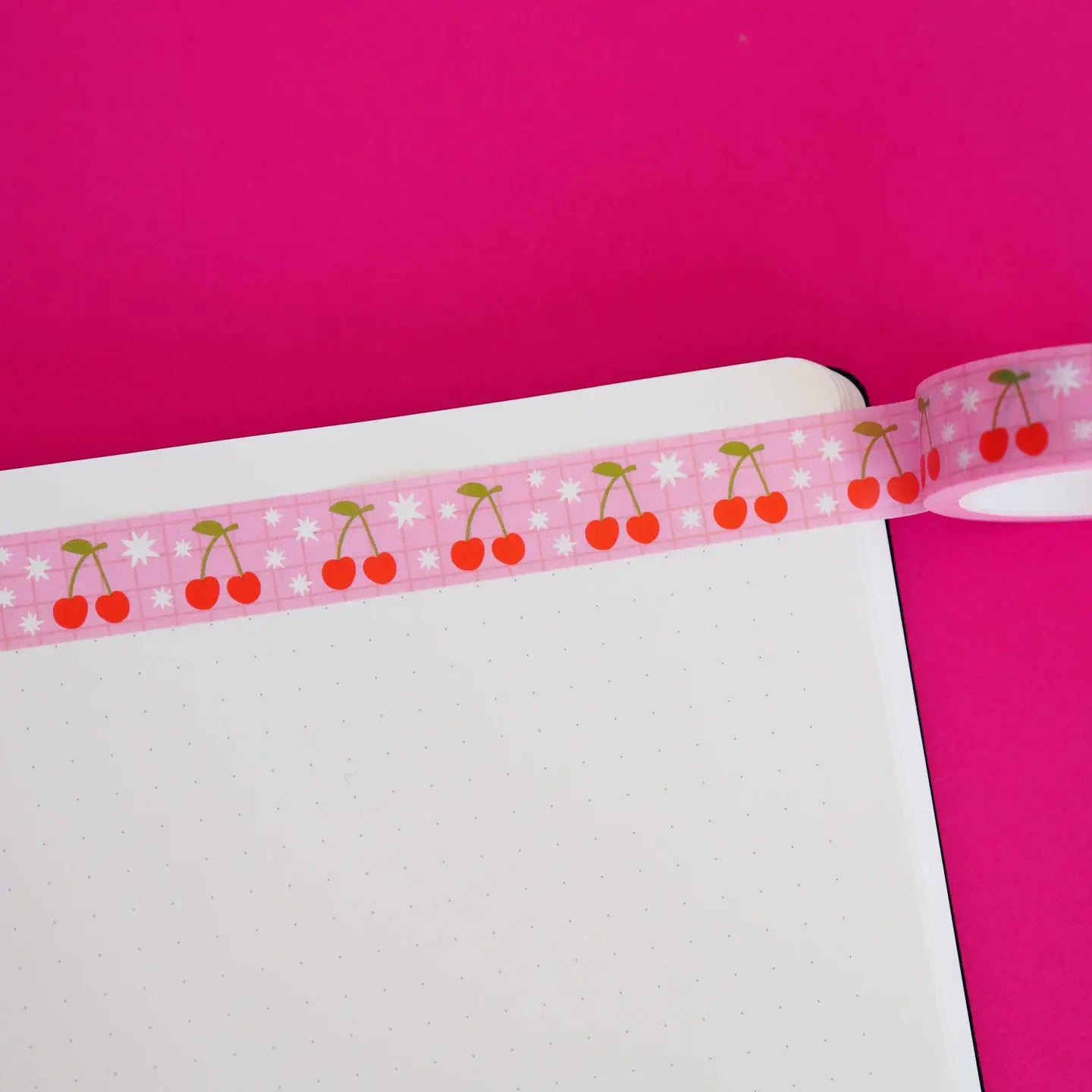 Decorative tape with cherry pattern on a pink background.