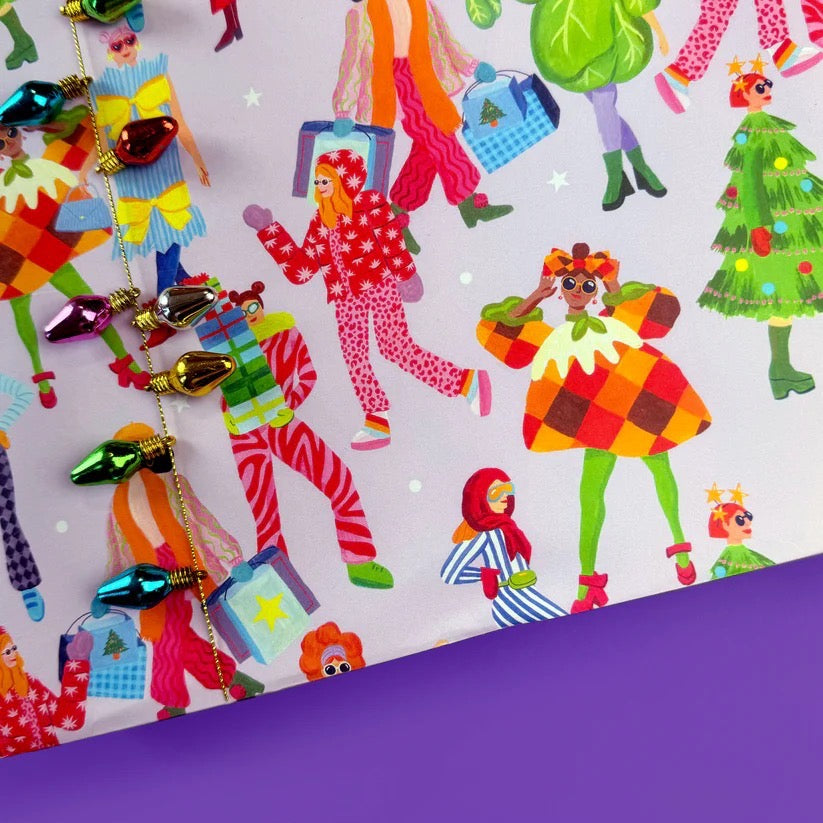 Close up of Christmas wrapping paper on a purple table.