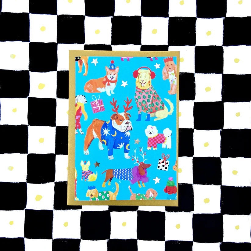 Card with cartoon dogs on a blue background, placed on a black and white checkered surface.