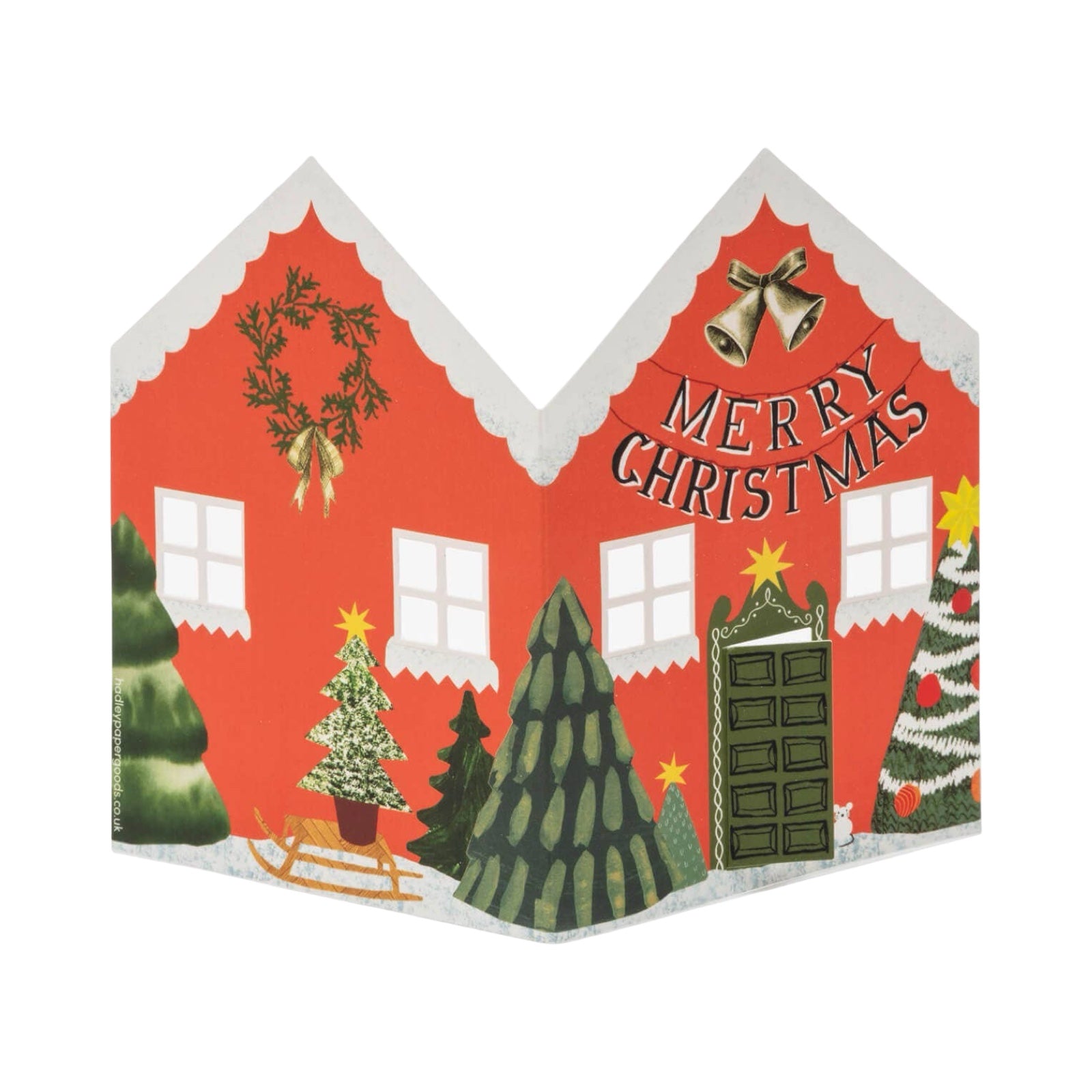 Decorative Christmas card with a house design, trees, and 'Merry Christmas' text on a white background.