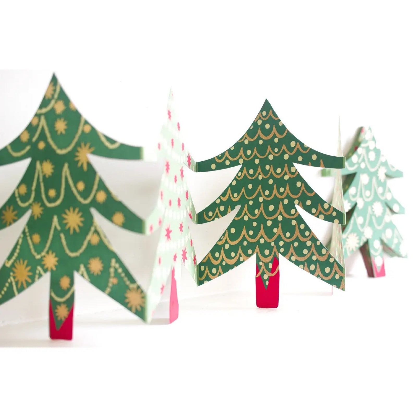 Christmas tree concertina garland with green patterned trees standing on a  white shelf.