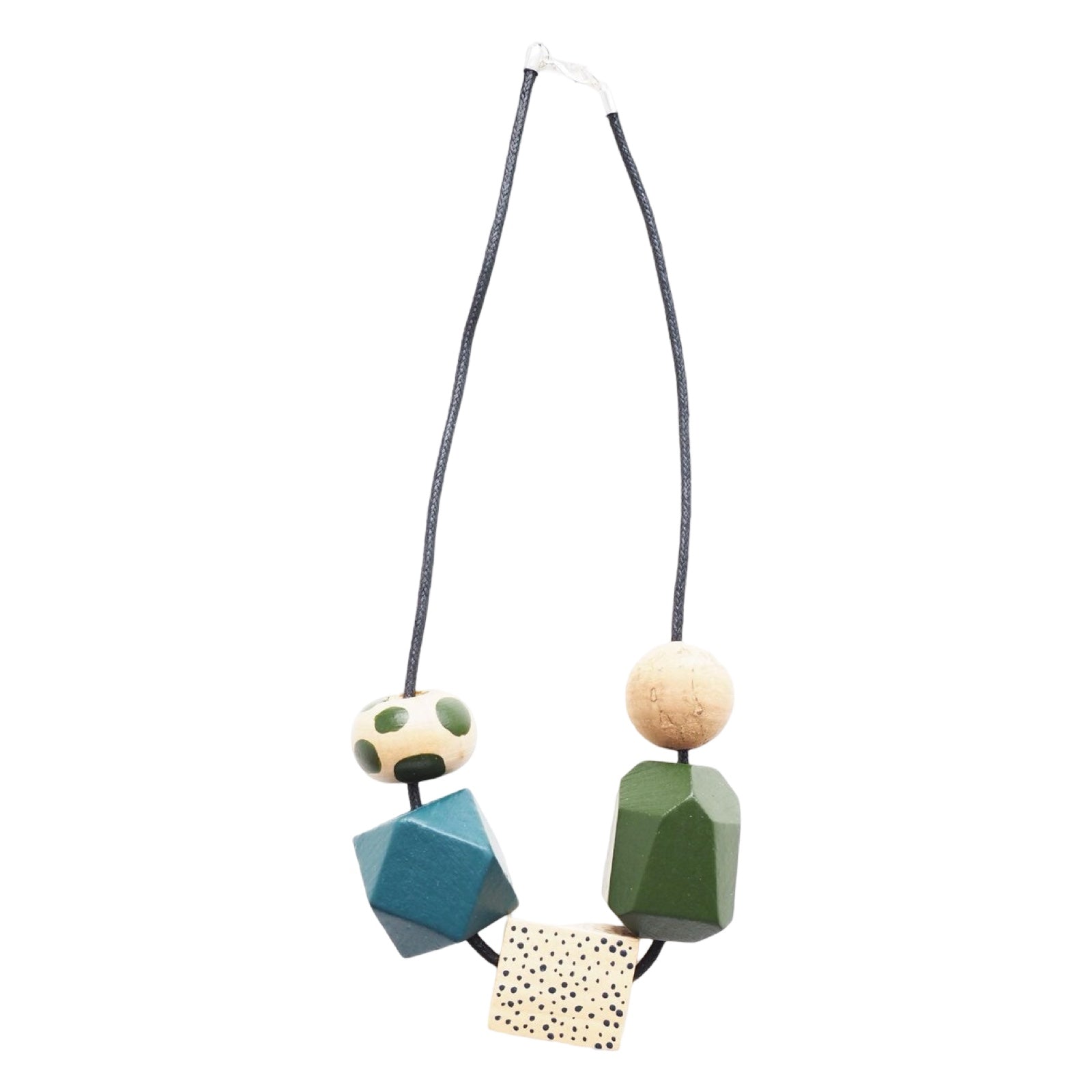 A chunky wooden necklace with 5 large colourful hand-painted beads, 1 plain green, 1 plain teal, 1 polka dot green, 1 with small black spots and 1 cork threaded on a black cotton cord.