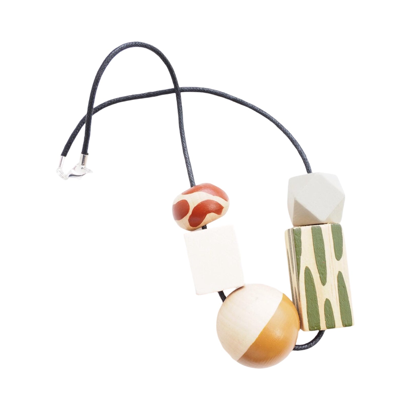 A chunky wooden necklace with 5 large colourful hand-painted beads, 1 with red dashes, 1 white cube, 1 mustard and white sphere, 1 rectangle with green dashes and 1 grey threaded on a black cotton cord with a silver-plated fastening.