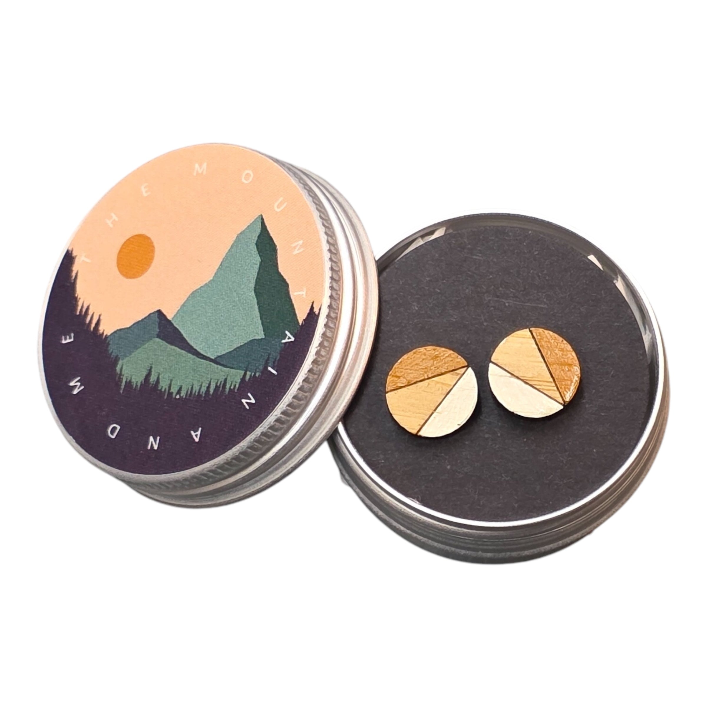 A pair of mustard and white painted circular wooden stud earrings in a small metal tin.