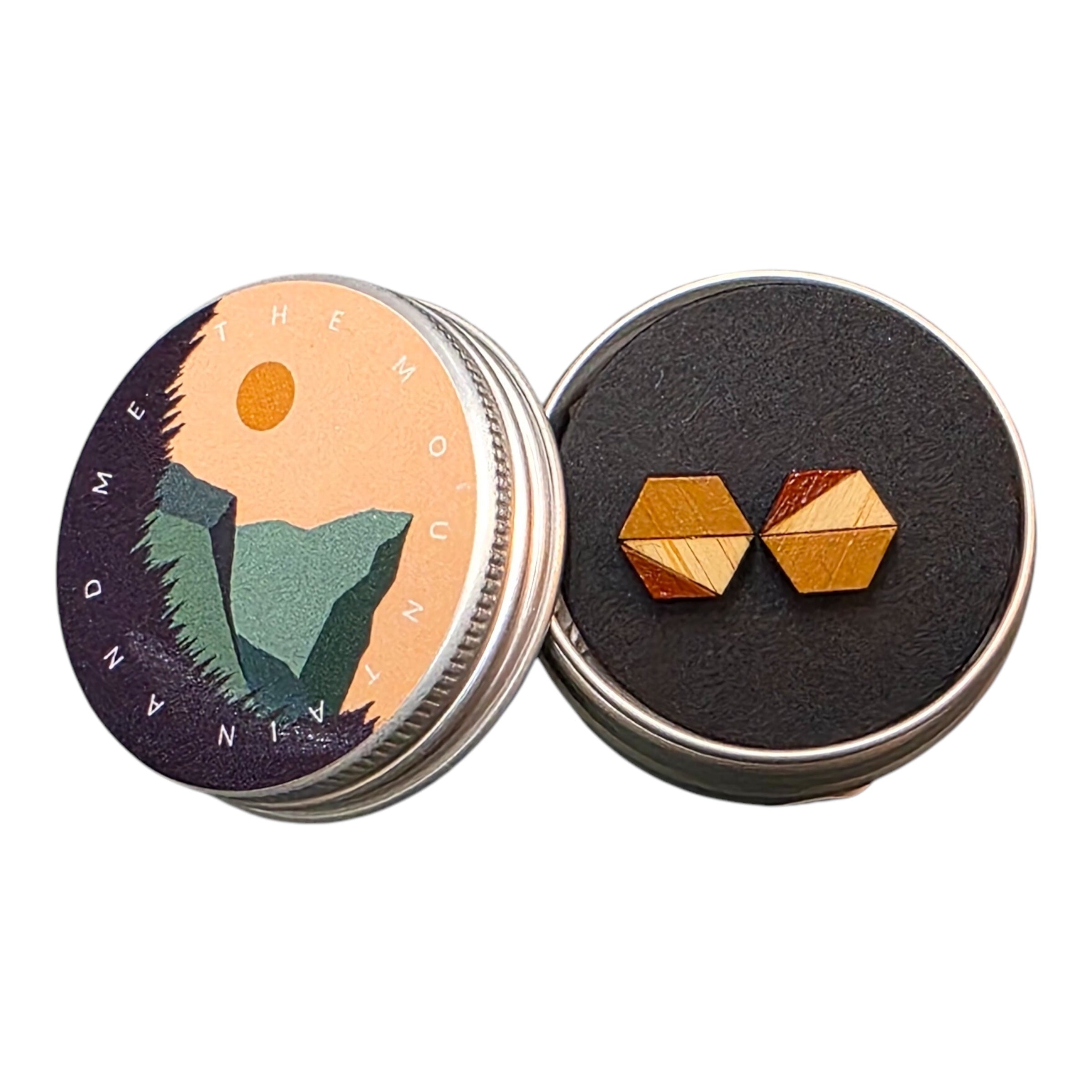 A pair of mustard and red hexagonal bamboo stud earrings in a small metal tin.