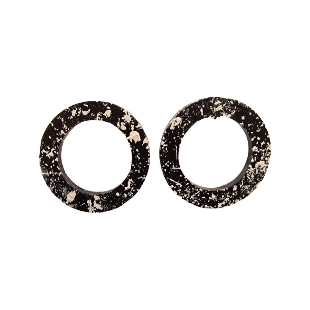A pair of round hoop earrings with a black and white splash design, silver plated studs.