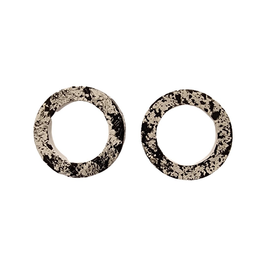 A pair of round hoop earrings with a black and white splash design, silver plated studs.