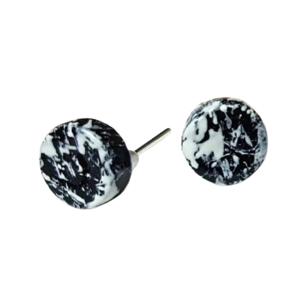 A pair of round monochrome stud earrings with a black and white splash design, on silver plated studs.