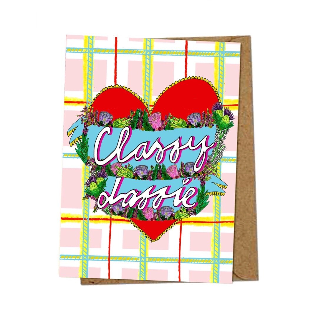 'Classy Lassie' card featuring an illustration of a red love heart on a tartan background and the text 'Classy Lassie' written inside the heart in banners surrounded by flowers.