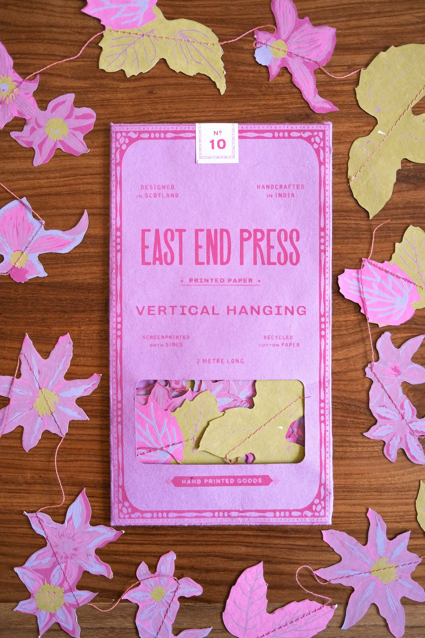 Pack of East End Press vertical hanging paper on a wooden surface with decorative flowers.