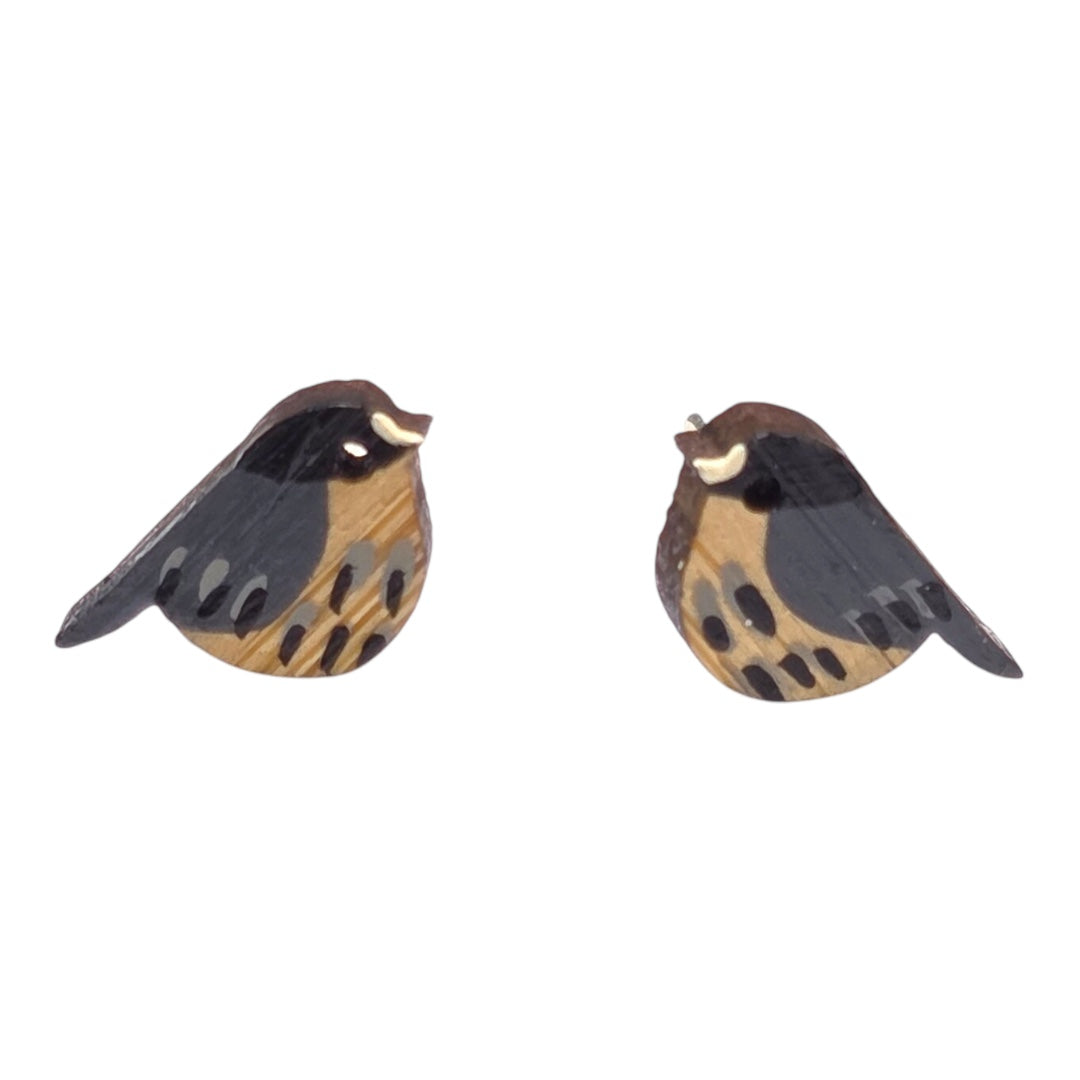 A close up of two small wooden earrings shaped like birds. 